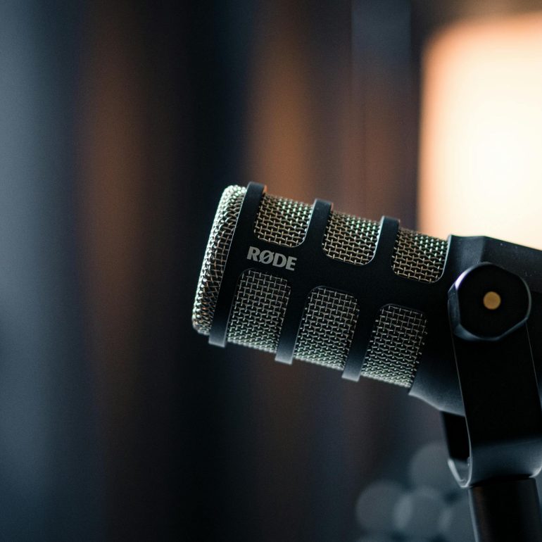 Close-up of a Rode microphone in a studio, emphasizing professional audio equipment.